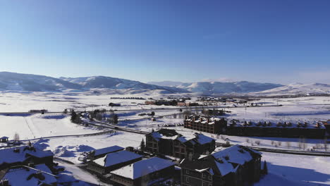 Cars-pass-in-front-of-rocky-mountains-during-winter-day-in-Granby,-Colorado