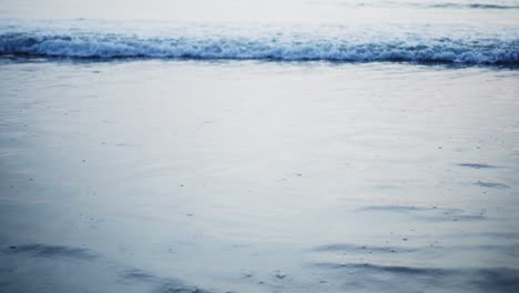 Slow-Motion-Nahaufnahme-Von-Wellen,-Die-Sich-In-Der-Abenddämmerung-Auf-Den-Strand-Bewegen