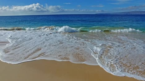 Panning-Wellen,-Die-Auf-Sandstrand-In-Maui-Hawaii-Mit-Schönem-Himmel-Und-Wasser-Zusammenstoßen