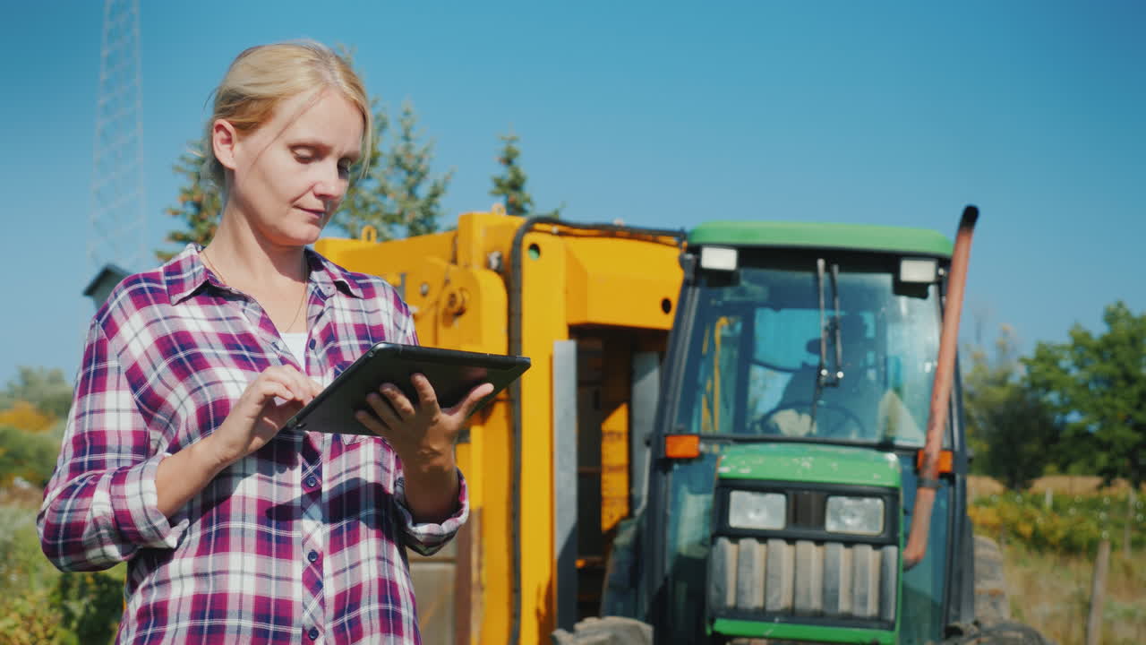 젊은 여성 농부는 농업 현장 기술에서 태블릿을 사용합니다.