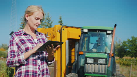una joven agricultora usa una tableta en una tecnología de campo en agricultura