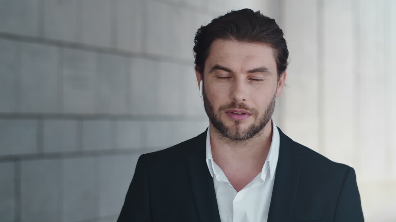 길거리에서 이어폰을 사용하는 사업가. 블루투스 이어폰으로 말하는 사업가