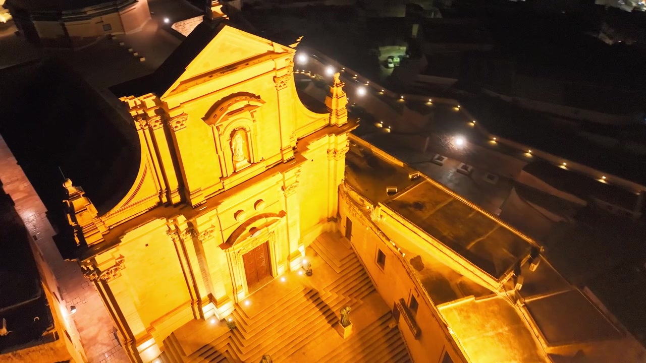 Ripresa con drone della Cattedrale dell'Assunzione di notte. Architettura barocca illuminata della Cattedrale di Gozo, situata nel cuore dell'antica Cittadella, Malta