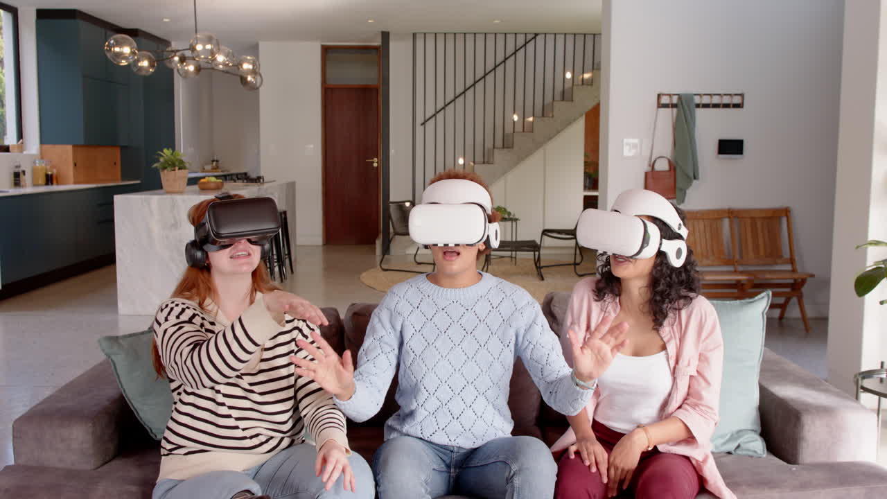Using VR headsets, diverse female friends experiencing virtual reality together on couch