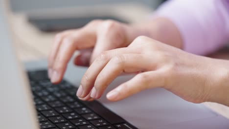 close up hand of a business woman typing keyboard laptop computer on desk office