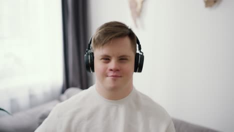 A-guy-with-down-syndrome-having-great-time-on-the-living-room-at-home-listening-music