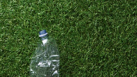 close up of plastic bottle trash on grass background, with copy space