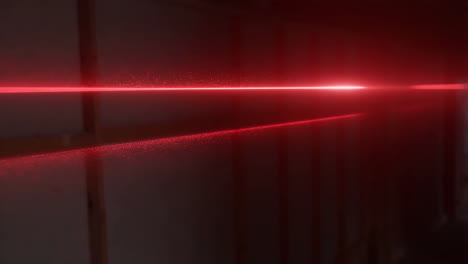 red laser beam illuminating dust particles in a dark room