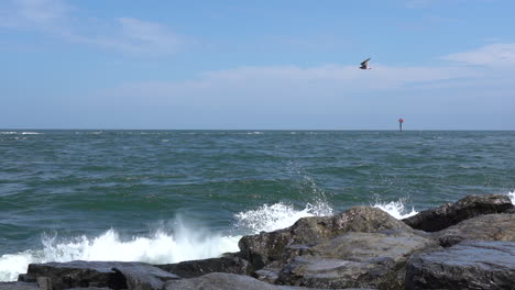 slow motion video of the waves from the ocean breaking over the rocks on the shore