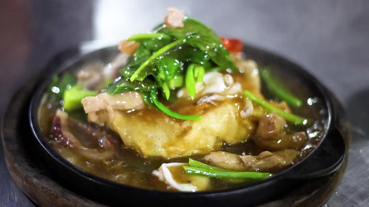 Steaming fried noodles with vegetables and meat, vibrant lighting, slight camera movement, lively street setting