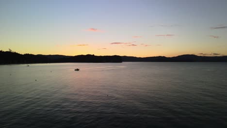 Cinematic-aerial-drone-shot-over-moored-boat-in-Cooks-bay,-New-Zealand