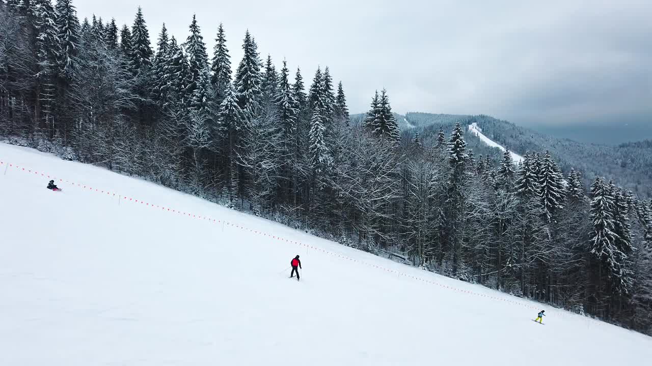 Pendio montuoso con pista da sci e persone. Abeti ricoperti di neve. Inverno a Bukovel, Ucraina