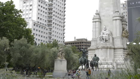 don quixote's and cervantes monument with people wandering around in plaza españa madrid