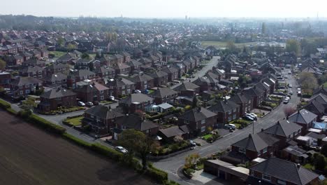 Urbanización-Aérea-Elevación-Aérea-Izquierda-Vista-Volando-A-Través-De-Inglaterra-Tierras-De-Cultivo-Comunidad-Residencial-Hogares