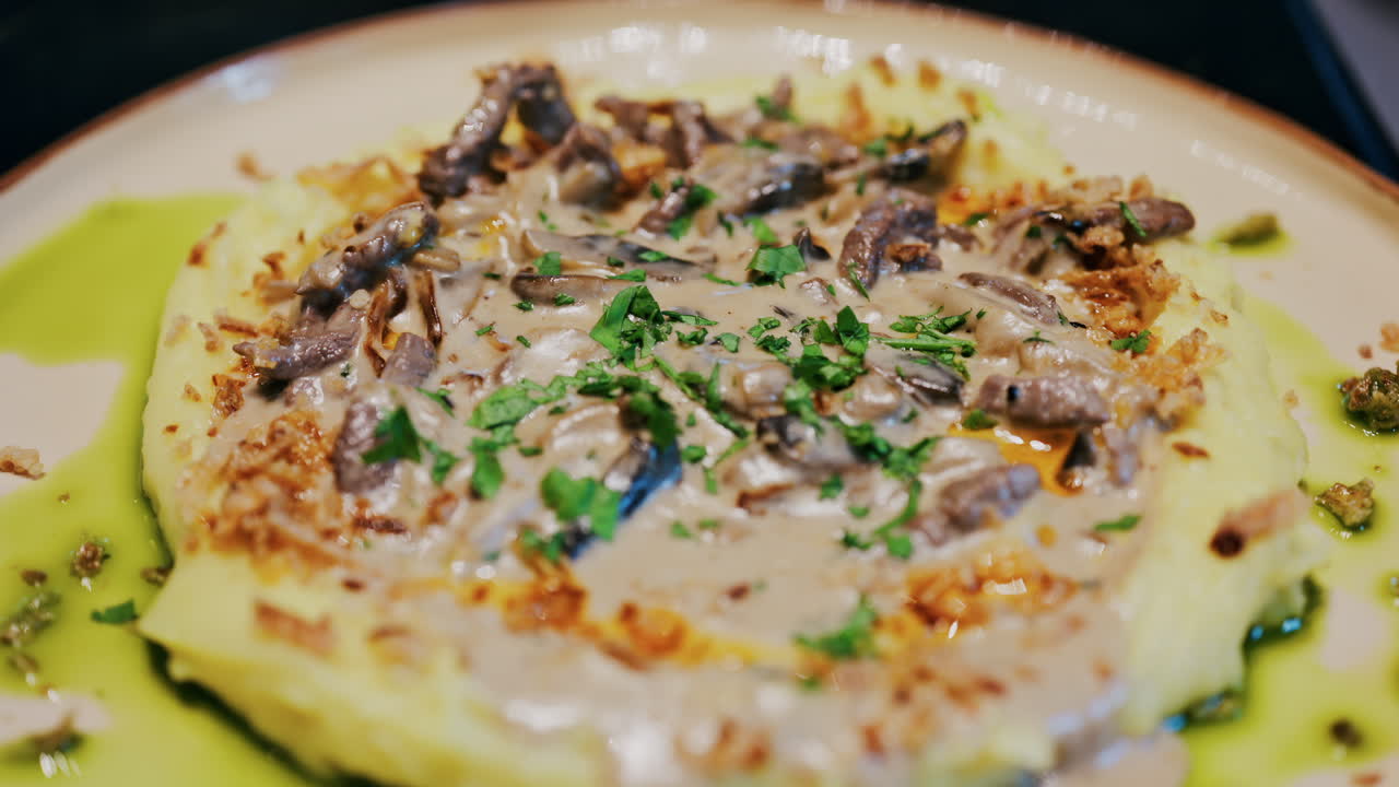 Close up of a creamy mushroom sauce over mashed potatoes on a plate at a restaurant