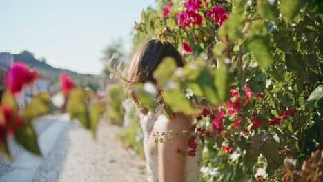 carefree woman sniffing roses touching flowers branch closeup. girl spinning