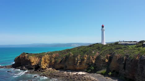 La-Entrada-De-Aireys-Sobrevuela-La-Antena-Del-Faro,-Los-Acantilados-Y-La-Playa,-Great-Ocean-Road,-Victoria,-Australia