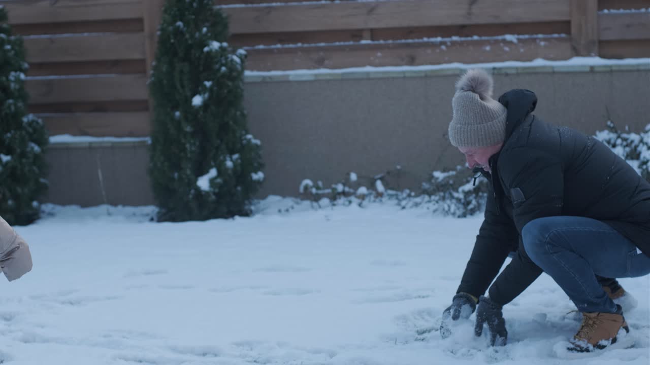 할아버지와 손녀가 눈 속에서 재미를 느끼고 있습니다.