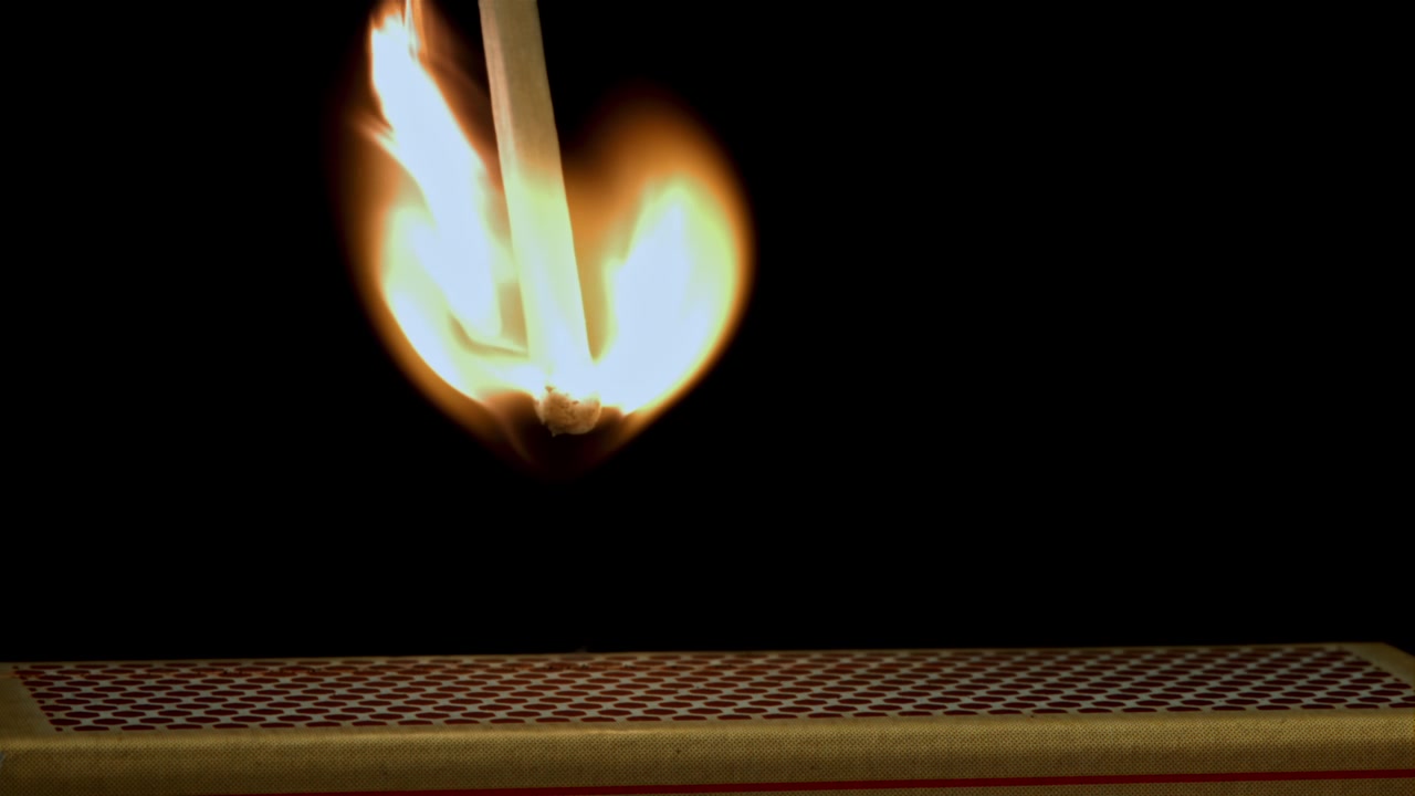 Matchstick Igniting and Burning in Slow Motion on a Black Background