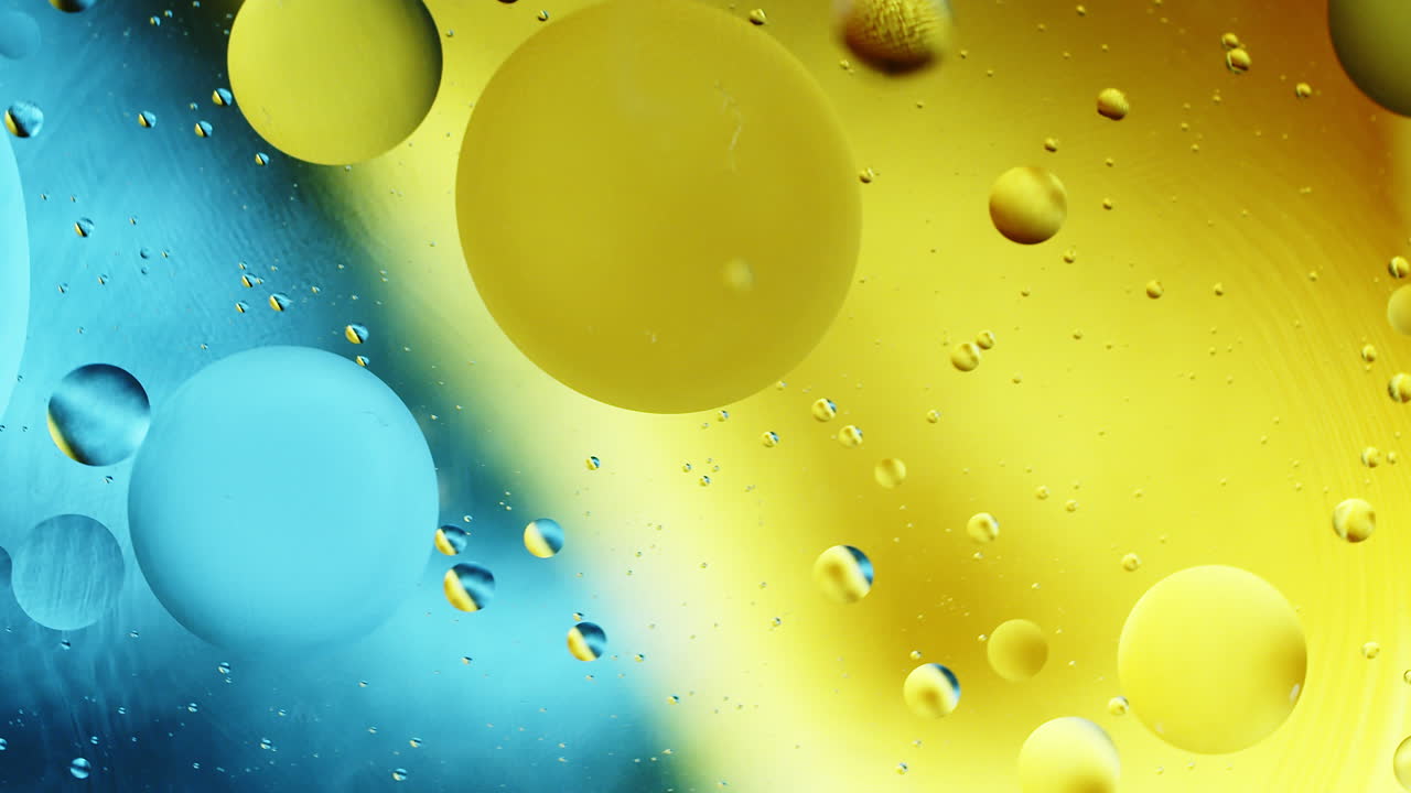 Real abstract colourful oil drops in water rotation with color gradient mixing background