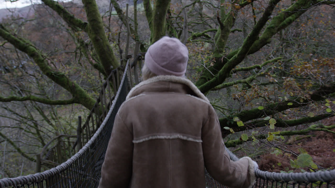 mujer caminando por el puente natural en la casa del árbol