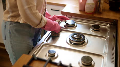 woman cleaning a stove in the kitchen