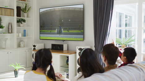 행복 한 가족 이 집 에서 함께 앉아서 tv 에서 육상 자벨린 대회 를 시청 하고 있다