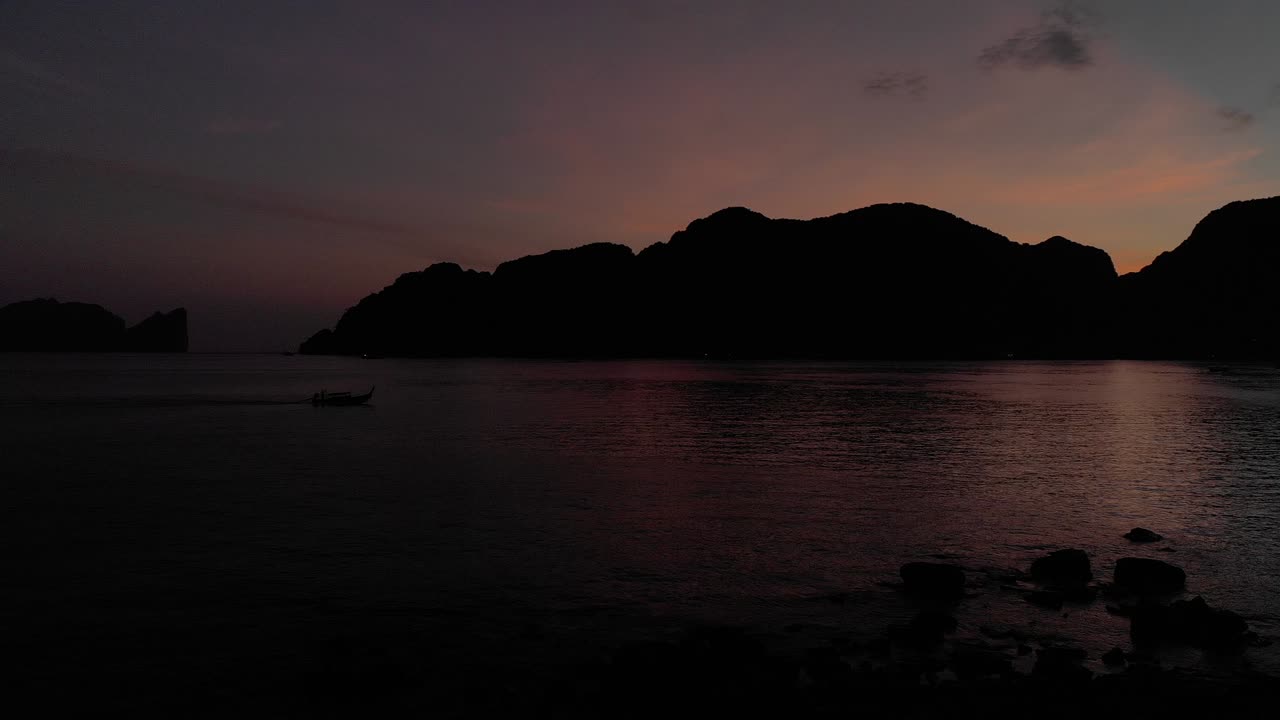 Sun set on Phi Phi Island with a boat passing through the sea
