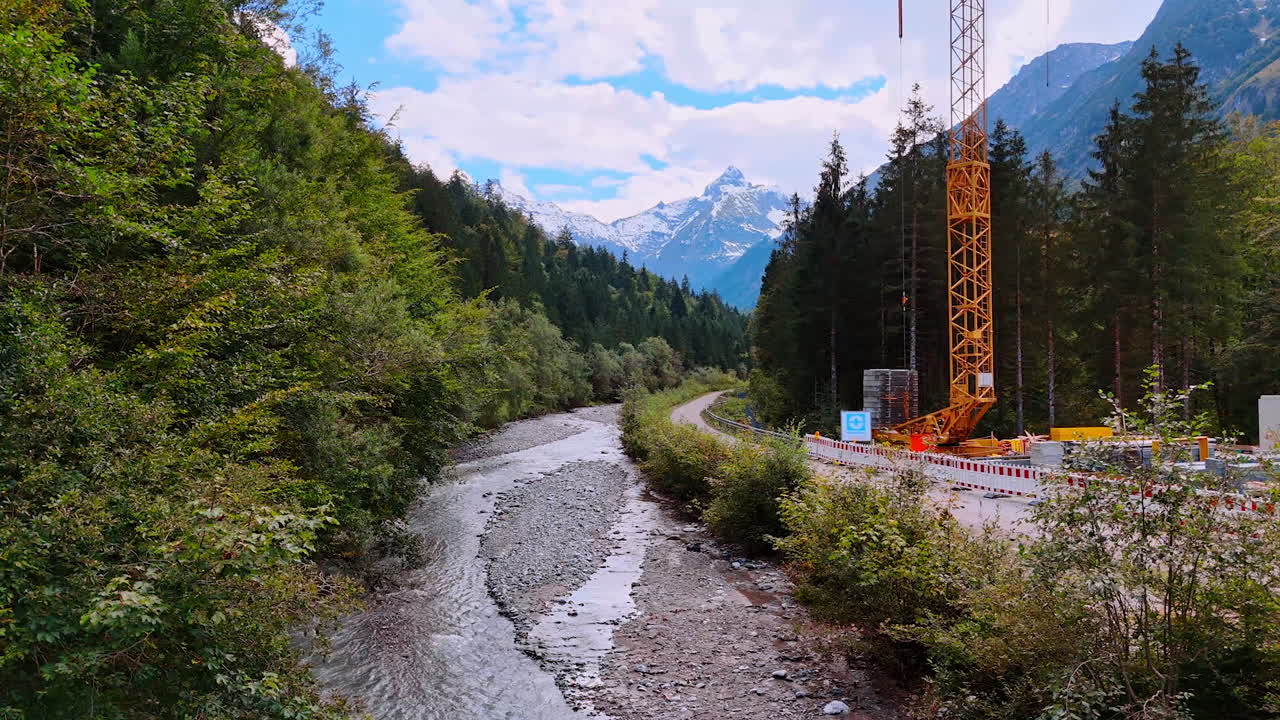 Mountainous river with little waterfall flowing by the rocky landscape. Stunning scenery of the Bavarian Alps at the backdrop of cloudy sky.