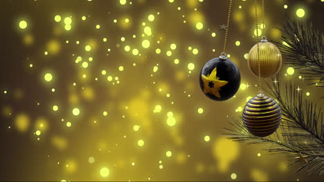 swinging black and gold christmas baubles over yellow light spots and bokeh lights