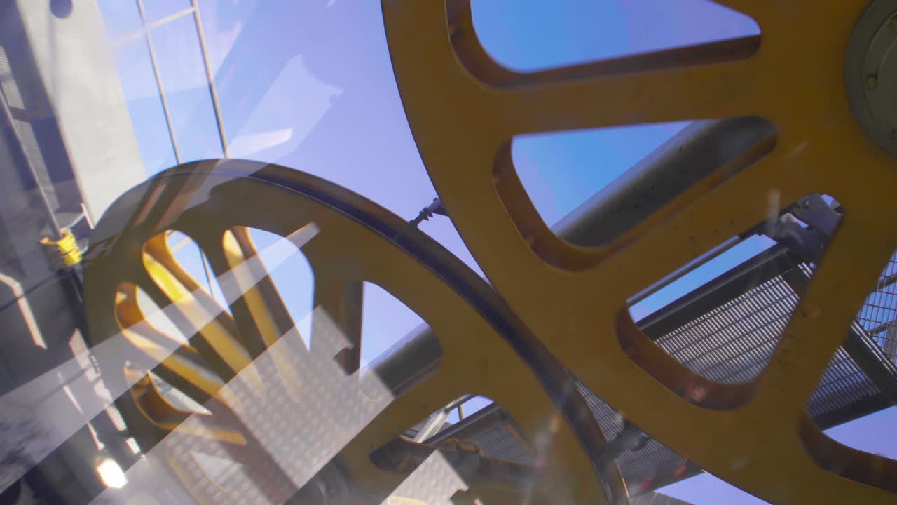 Big yellow gears turning above Montjuic cable car in Barcelona in January