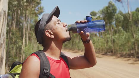 sporty mixed race man with prosthetic leg drinking water