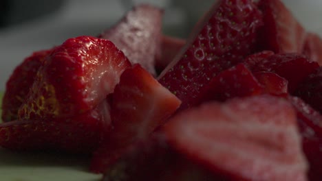 las fresas cortadas en la tabla de cortar en la iluminación de la hora dorada
