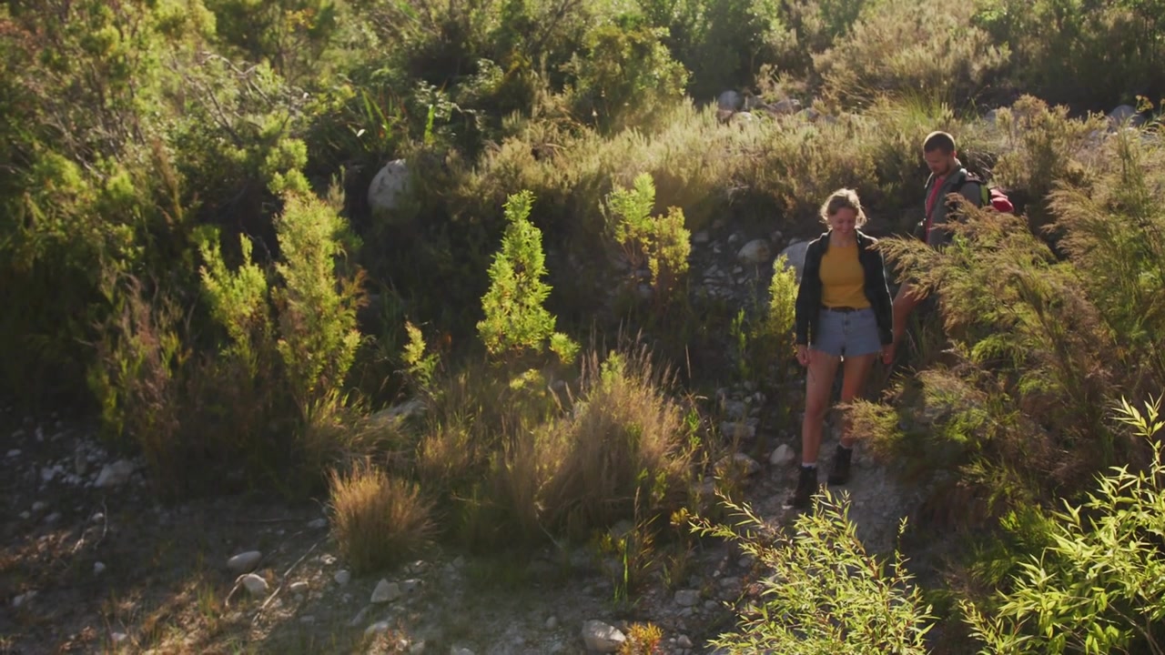 Donna in testa, uomo che segue, che iniziano la discesa su un pendio per un viaggio, con il testo "GOOD VIBES" che svanisce sul duo.