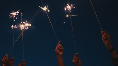 hands-holding-sparklers-celebrating-new-years-eve-holiday-at-night