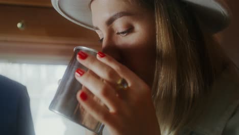 woman drinking beverage in camper van