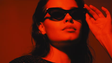 woman in red light with sunglasses