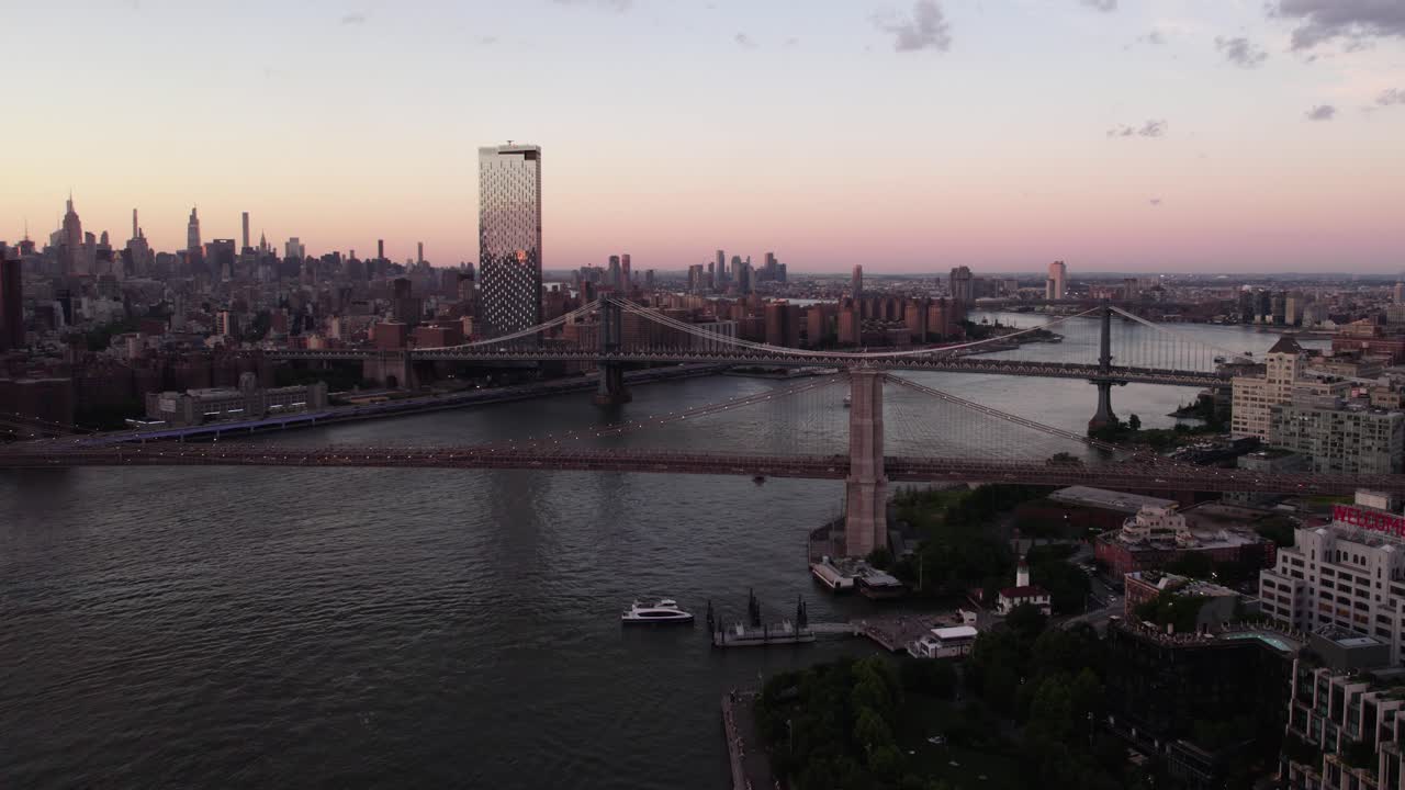 Aerial view of a ferry arriving at the Brooklyn Bridge Park - Pier 1, dusk, in NY, USA - pull back, drone shot