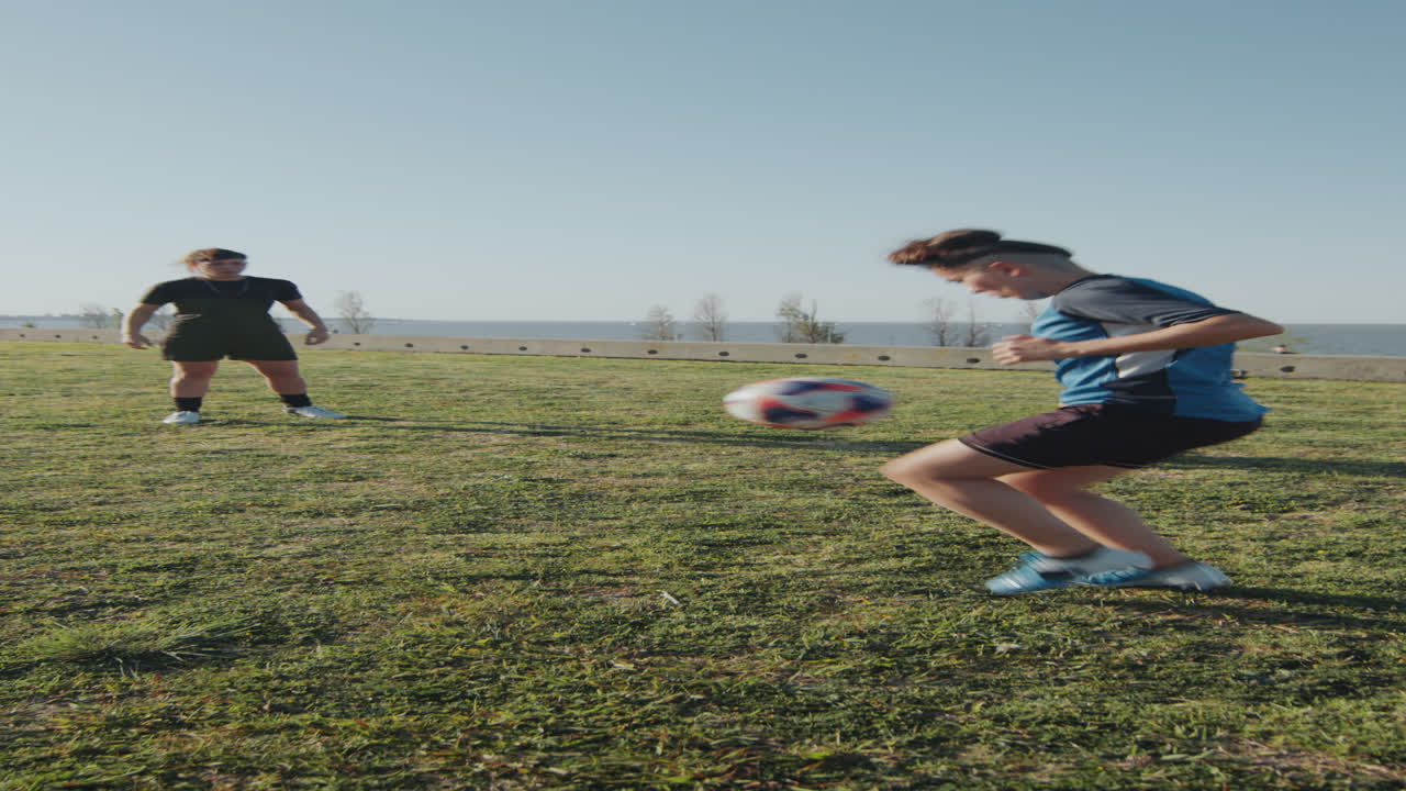 dos chicas atléticas pasando una pelota de fútbol en un día soleado