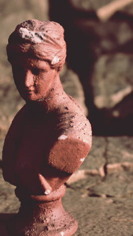 a close up of a small, aged bust of a woman