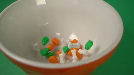 close up of bones and skulls shaped candy falling on a plate