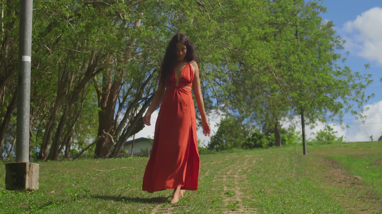 Con un vestito vivace, una giovane ragazza latina si gode il tempo in un parco a Trinidad, un'isola caraibica.