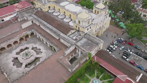 rotación aérea volando alrededor del frente de una catedral amarilla en antigua, guatemala