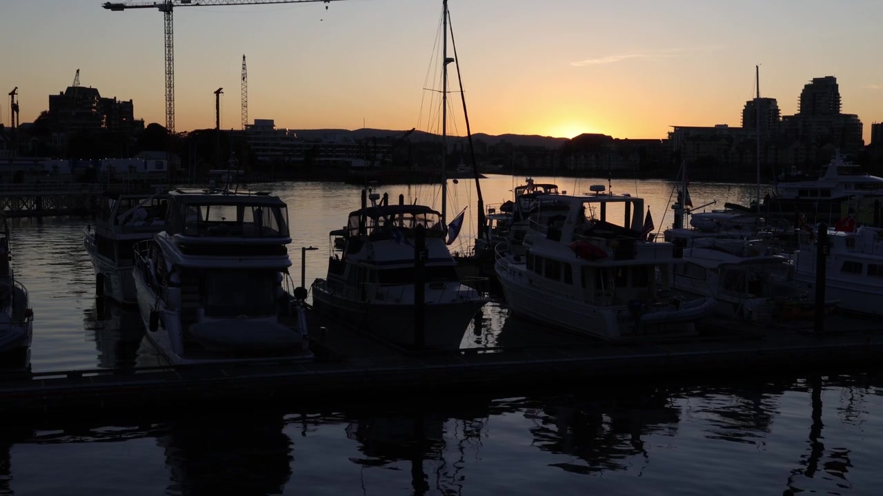 Boote im Yachthafen bei Sonnenuntergang, abendlicher Hafen als Hintergrund.