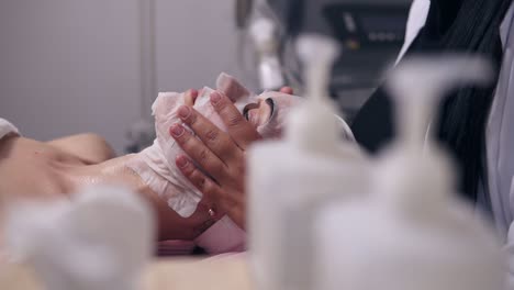 professional carboxytherapy. female cosmetologist applying special mask on woman's face and neck. camera movement through