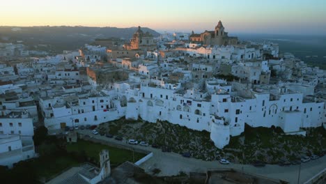 Drohnen-Dolley-Aufnahme-Der-Weißen-Italienischen-Stadt-Ostuni-Während-Eines-Farbenfrohen-Sonnenuntergangs