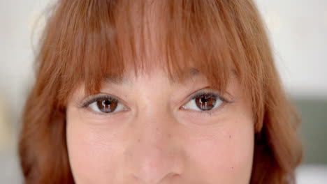 close-up of a young biracial woman with brown eyes and bangs