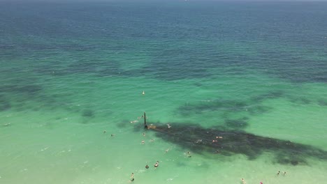 A-dynamic-aerial-shot-of-a-swimming-tourists-on-Coogee-beach-with-the-Omeo-shipwreck
