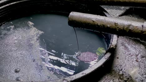 black chemical wastewater on the storage tank coming out from pipe from industrial processes