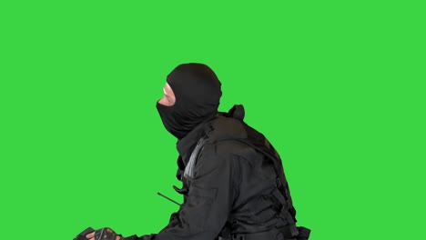 de oproerpolitie zit met de helm uit en rust op een groen scherm, chroma-sleutel.